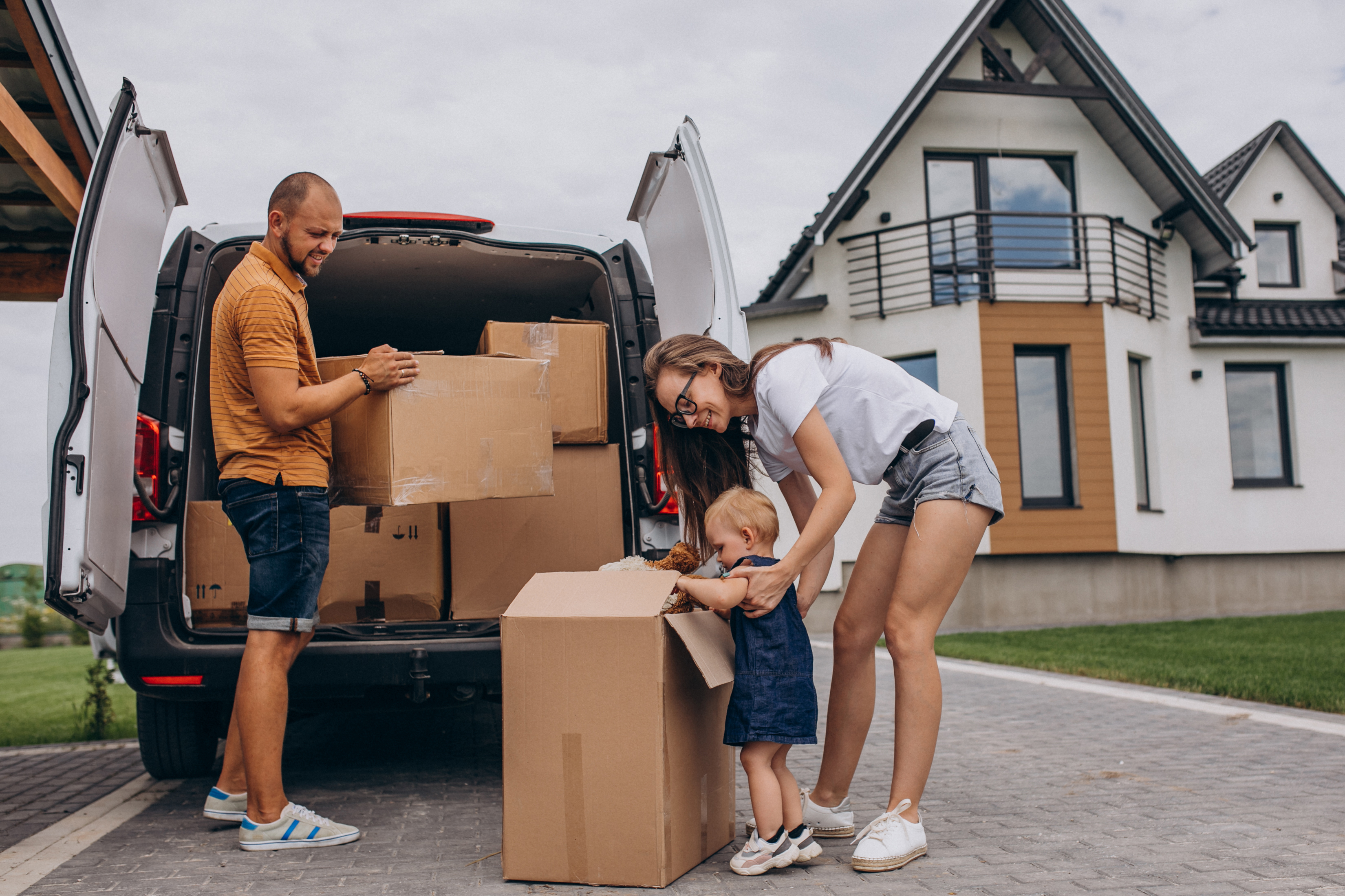 Family loading moving boxes into a truck during relocation season in a Texas suburb near Fate